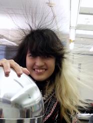 Student with her hand on a static ball and her hair standing up