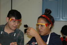 Two students wearing safety goggles during an AP Chem Lab